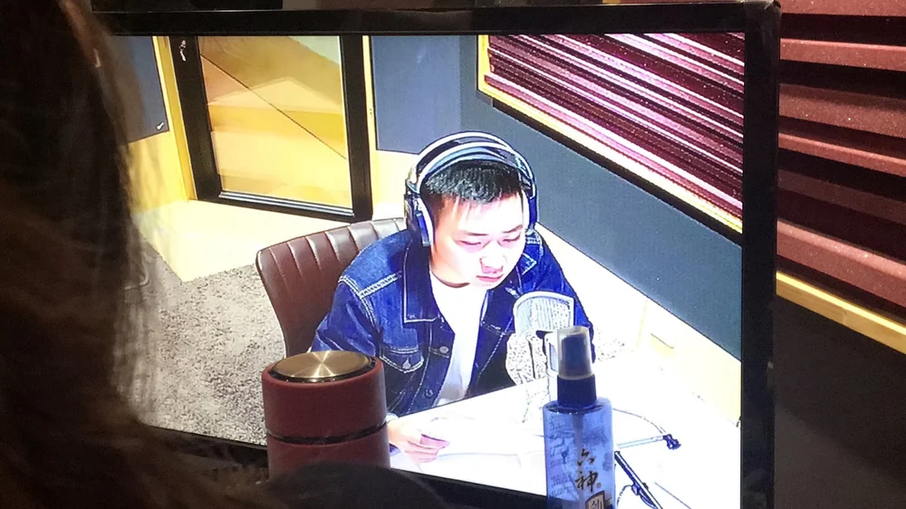 Roots working with a microphone in a voice recording studio in Beijing