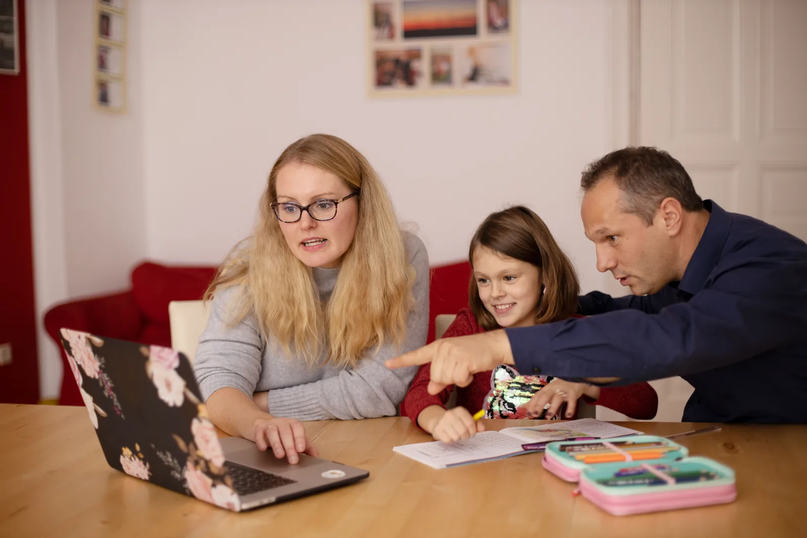 Parents supporting their child during an online lesson at home