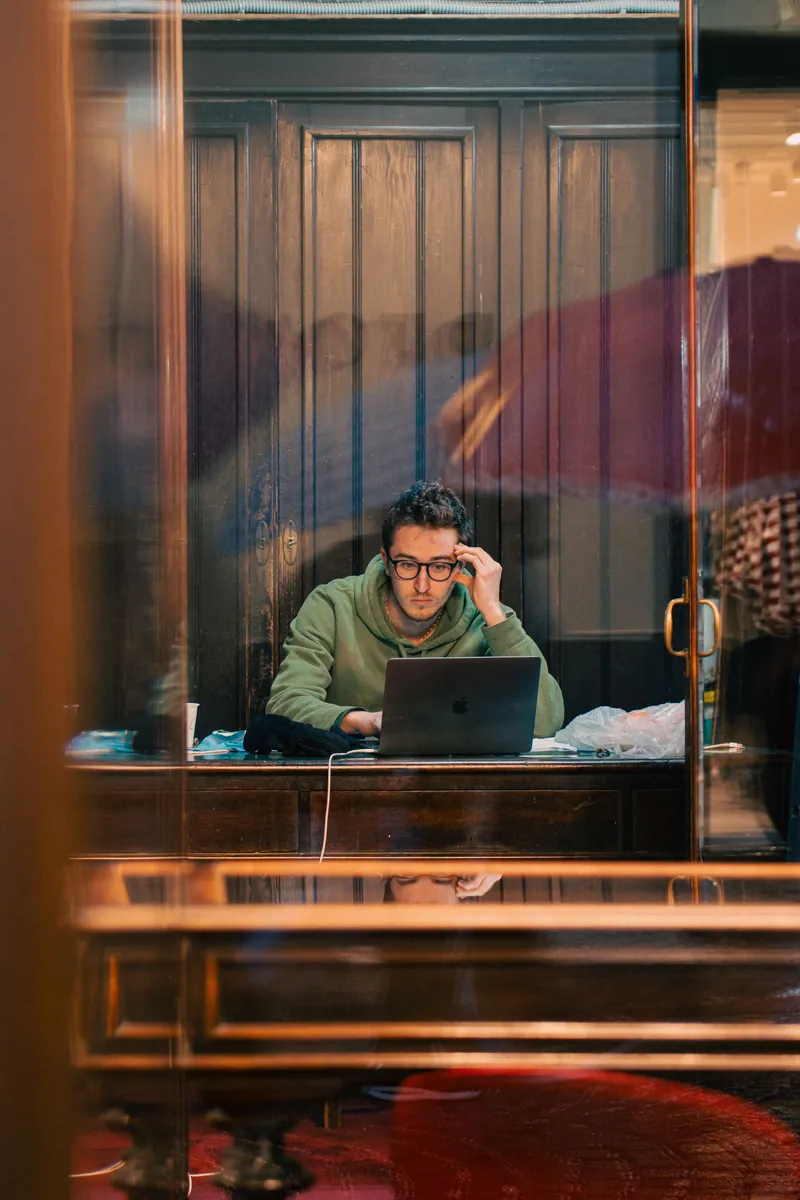 Adult learner working naturally on a laptop in a café