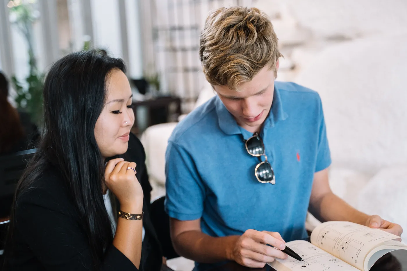 Two adult learners discussing a book together